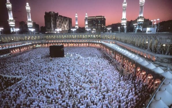 MECCA, SAUDI ARABIA - DECEMBER 2002:  Muslims pray at dusk around the Kaaba, Islam's most sacred sanctuary and pilgrimage shrine, within the Masjid Al-Haram mosque on Eid ul-Fitr day which ends Ramadan (the month of fasting) on December 2002 in Mecca, Saudi Arabia. (Photo by Reza/Getty Images)