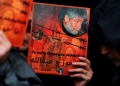 A supporter of Lebanese militant Georges Ibrahim Abdallah holds up a placard bearing his portrait and a slogan in French and Arabic reading: 'I am Georges Abdallah' during a protest outside the French embassy in Beirut demanding his release on February 20, 2015.