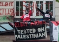 Palestine Action activists occupy the balcony at the offices of Israeli arms company Elbit Systems on August 6, 2021 in London, England