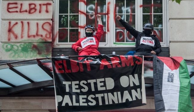 Palestine Action activists occupy the balcony at the offices of Israeli arms company Elbit Systems on August 6, 2021 in London, England