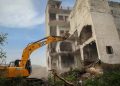 A bulldozer demolishes a Muslim-owned property in Nuh, Haryana